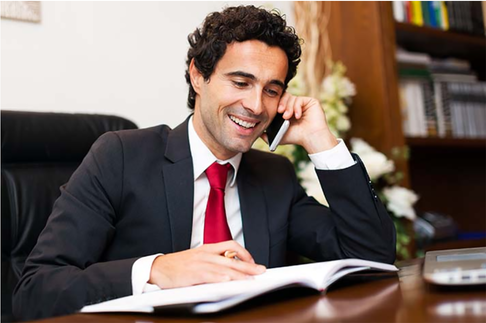 smiling man talking on phone in office