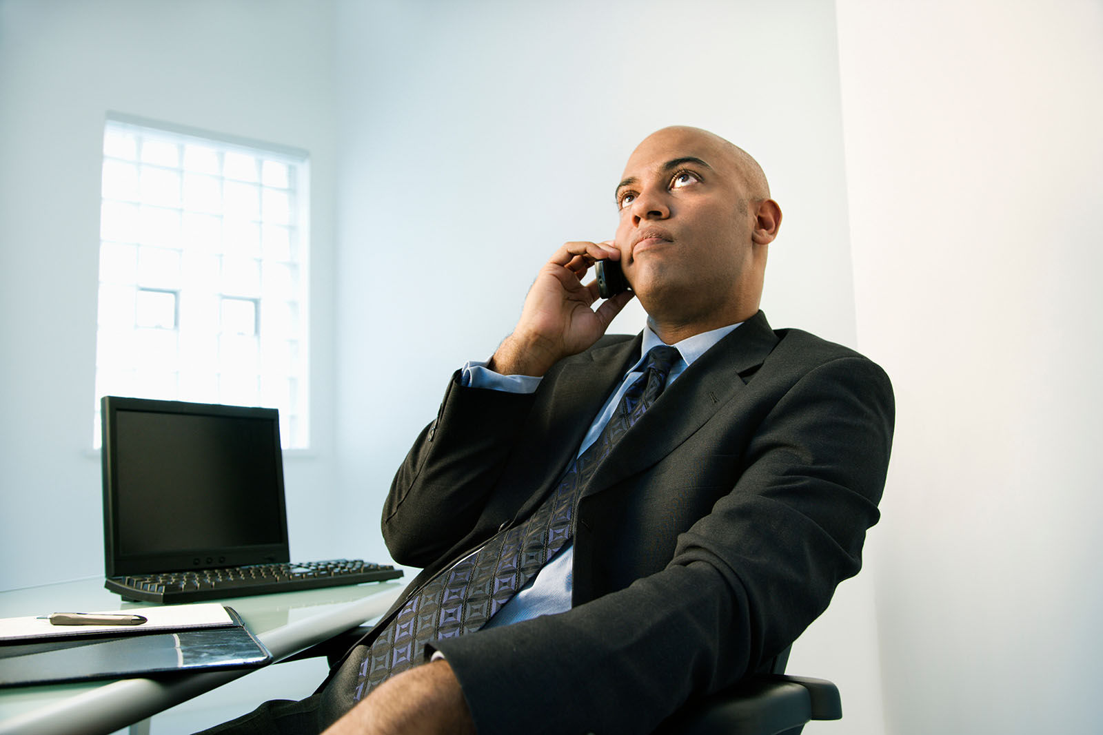 unhappy man waiting on phone in office