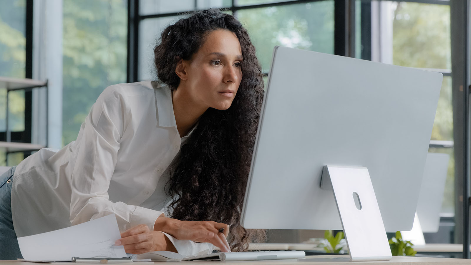 woman leaning toward desktop computer screen