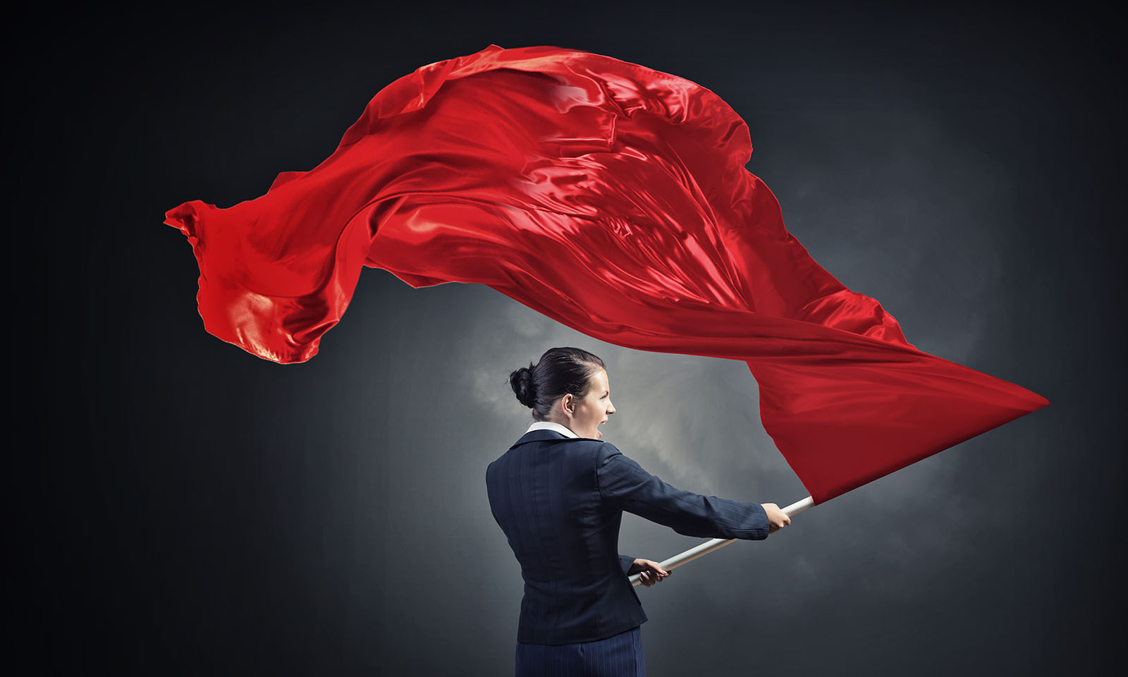 woman in a business suit waving a red flag