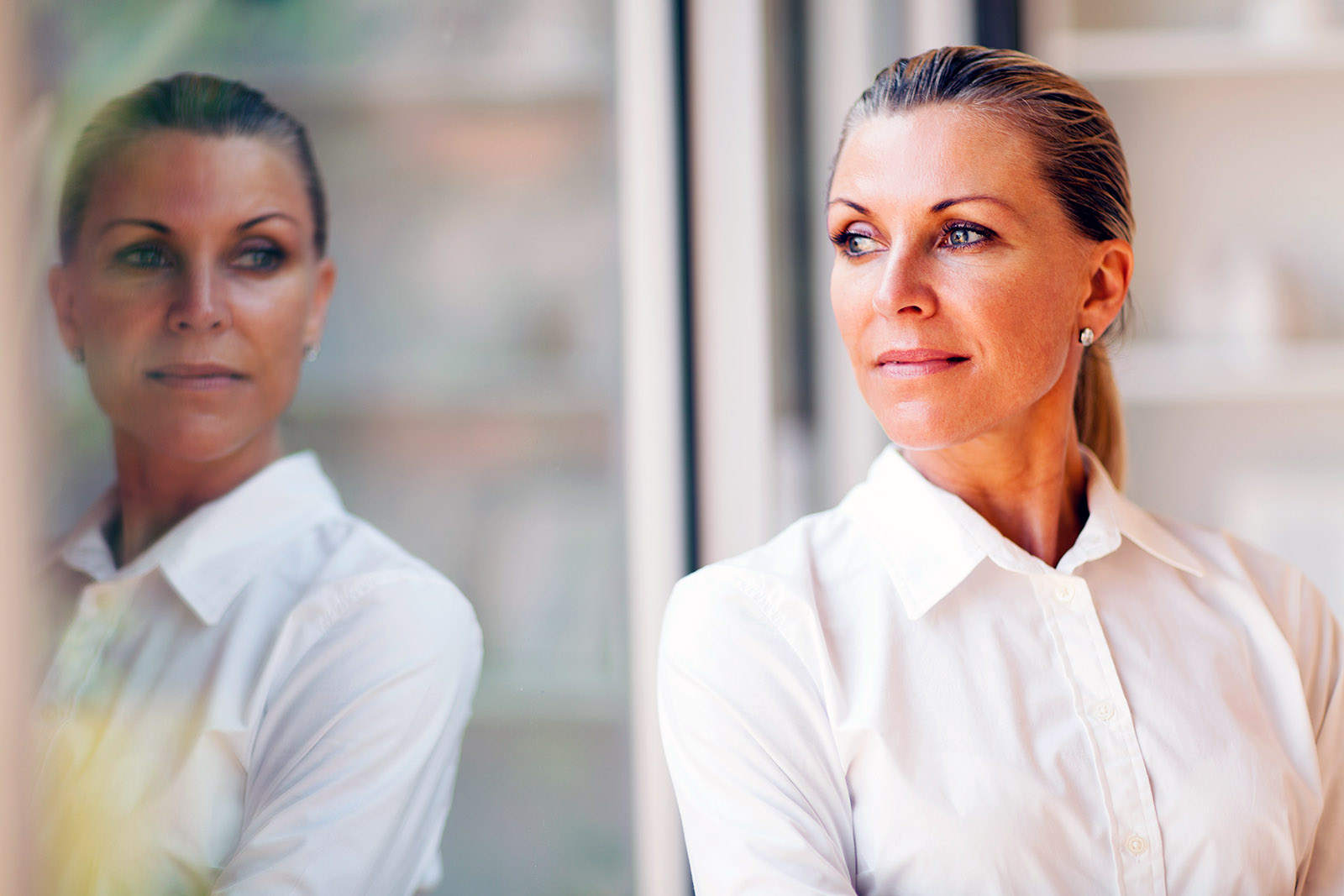 woman with ponytail reflected in window