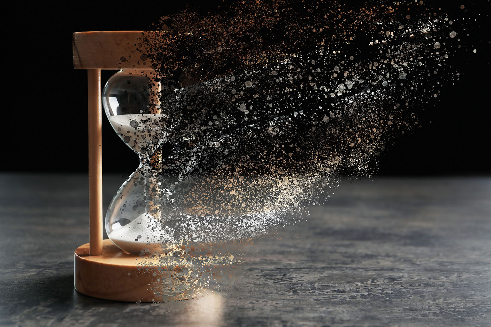 hourglass breaking, sand blowing away