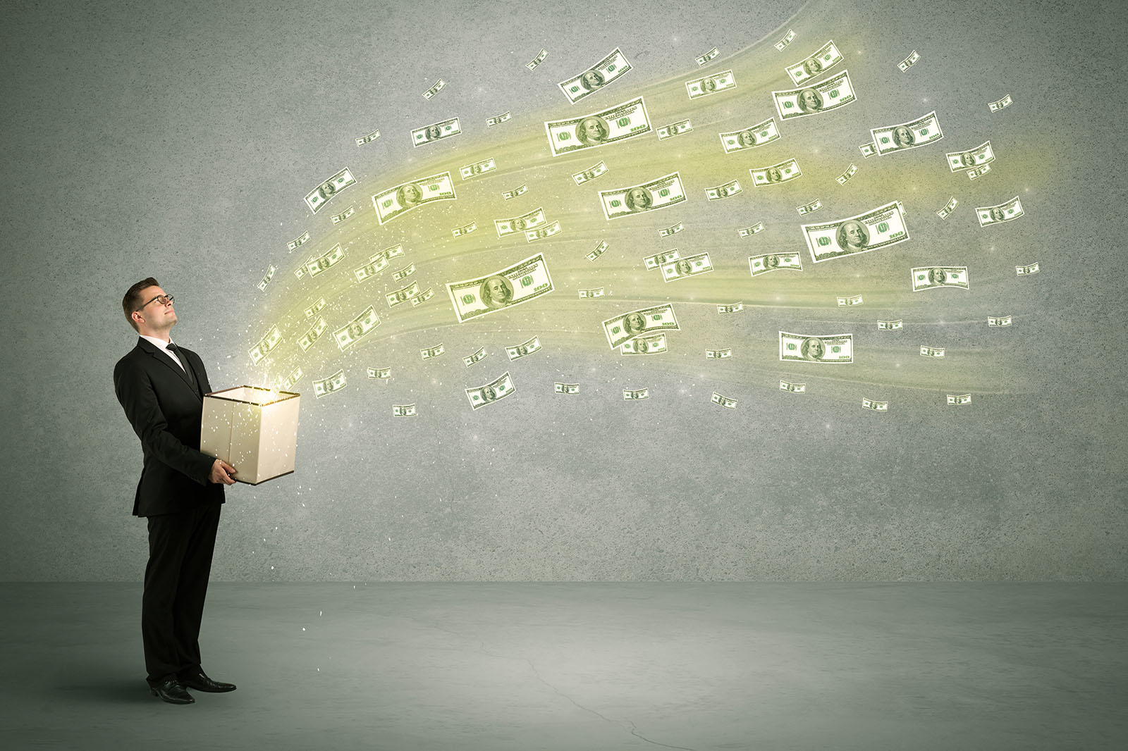 businessman holding box with money flying out of it