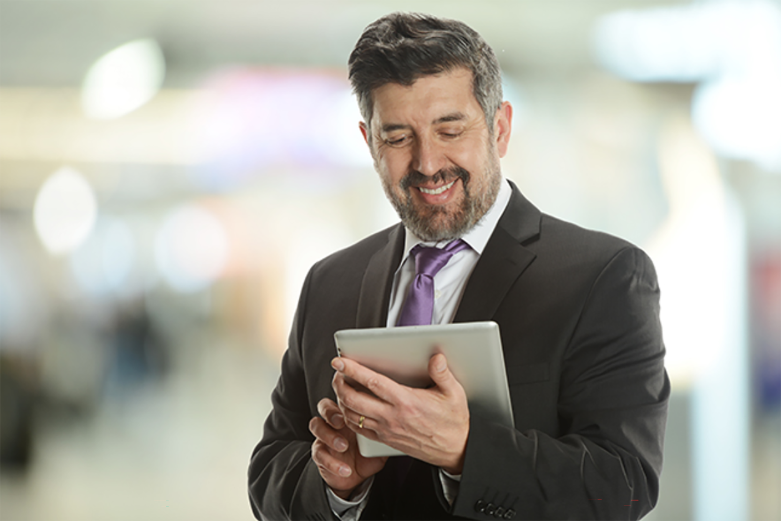 businessman smiling while looking at tablet