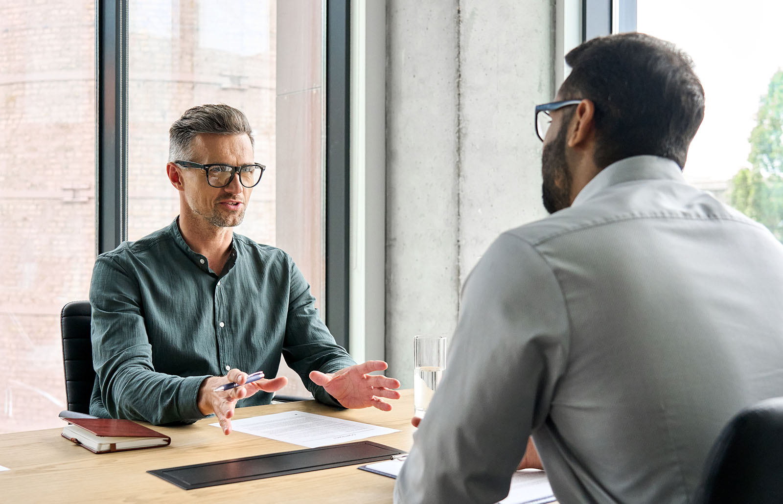 two men talking across table