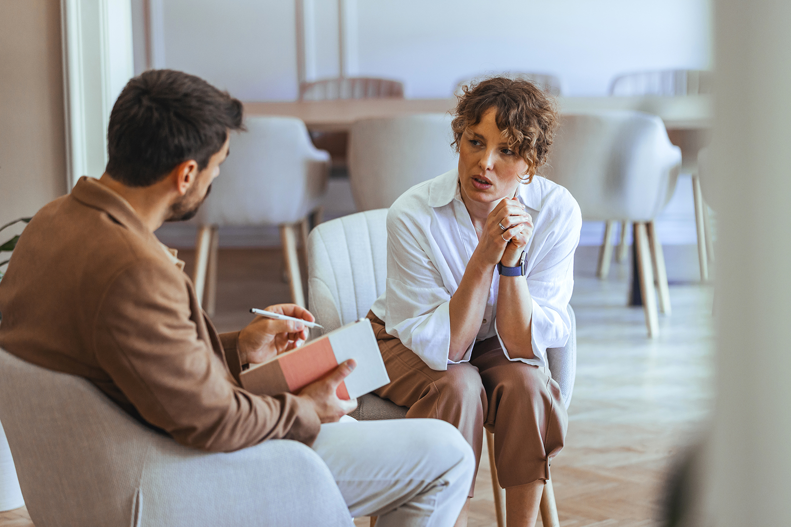 two seated people talking in office